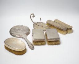 A George V silver mounted hand mirror, Birmingham, 1916, five assorted silver mounted brushes