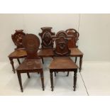 Four Victorian mahogany hall chairs and a Regency hall chair