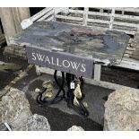 A rectangular cast iron and weathered teak garden table with a sign reading 'Swallows', width