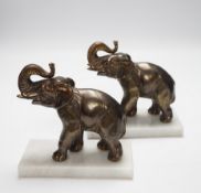 A pair of cast metal elephants on marble bases, 15.5cm high