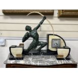 A French Art Deco bronzed spelter archer and cream and black marble mantel clock garniture, 50cm