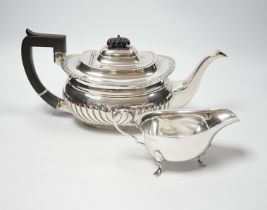 An Edwardian demi fluted silver teapot, London, 1904, together with a later silver sauceboat,