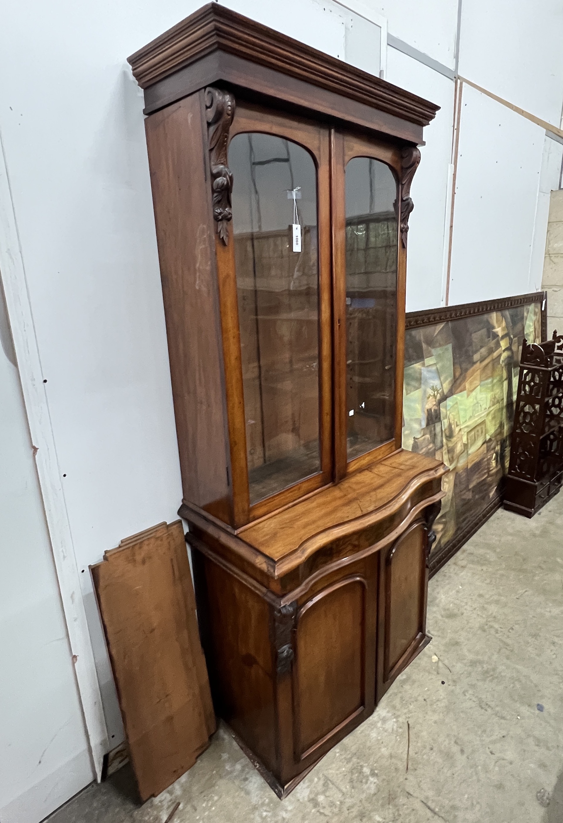 A Victorian serpentine mahogany bookcase cupboard, width 88cm, depth 48cm, height 205cm