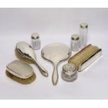 A silver mounted hand mirror and four similar brushes, together with four mounted glass toilet