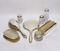 A silver mounted hand mirror and four similar brushes, together with four mounted glass toilet