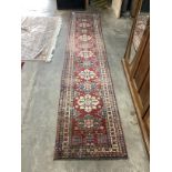 A Caucasian style red ground runner, 390 x 80cm