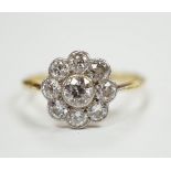 A 1930's/1940's 18ct and nine stone millegrain set diamond set flower head cluster ring, size P,