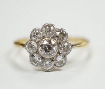 A 1930's/1940's 18ct and nine stone millegrain set diamond set flower head cluster ring, size P,