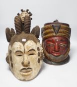 An Igbo maiden spirit mask and an African tribal helmet mask, largest 46cm wide