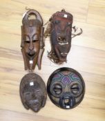 Four African tribal carved wooden masks, tallest 39 cm high