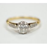 An 18ct, plat. and single stone diamond ring, with diamond set shoulders, the central stone