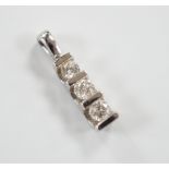 A modern 750 white metal and three stone diamond set pendant, 15mm, gross weight 0.9 grams.