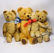 A golden plush bear with pale blue ribbon, 38cm, together with three others (4)