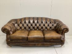 A Thomas Lloyd buttoned brown leather three seater settee, a two seater settee and a footstool,