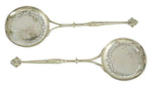 A pair of George V Asprey & Co pierced silver serving spoons, with dolphin handles and circular