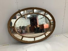 An early 20th century oval giltwood and composition marginal plate wall mirror, width 111cm,