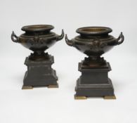 A pair of 19th century bronze urns on slate pedestals, 21.5cm high