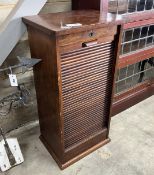 A 1920's oak cabinet with tambour front, width 45cm, depth 36cm, height 92cm