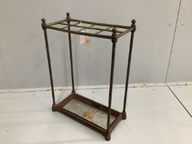 An early 20th century tubular brass and cast iron eight division stick stand, width 42cm, depth