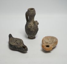 Two Roman oil lamps and an early ewer, tallest 14.5cm