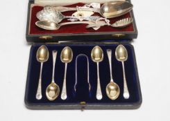 A cased set of six silver teaspoons and tongs and four other assorted silver or white metal