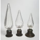 Three Large cut glass stoppers mounted on brass bases, highest 32.5cm