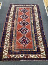 An antique Anatolian brick red ground rug, 244 x 140cm