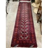 An Afghan red ground runner, 300 x 83cm