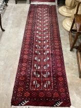 An Afghan red ground runner, 300 x 83cm