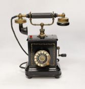 An early 20th century black enamelled metal telephone, 34cm high