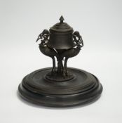 A late 19th century patinated metal inkwell, modelled with three cranes on an ebonised pine base,
