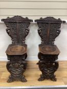 A pair of 18th century style Italian carved walnut hall chairs, width 48cm, depth 42cm, height