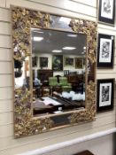 A rectangular marginal plate bevelled wall mirror, the part painted frame carved with grapes and