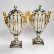 A pair of Rudolstadt gilt decorated urns and covers, 29cm