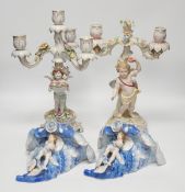 Two continental putti floral encrusted candelabra and two wall pockets, tallest 36cm high