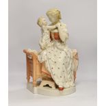 A large French porcelain seated ‘mother and child’ group and a pair of figural candlesticks,