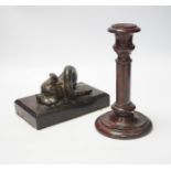 A 19th century serpentine candlestick and a carved dolphin paperweight, tallest 20cm high
