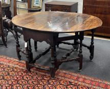 An 18th century oval oak gateleg dining table with turned under frame, width extended 146cm, depth
