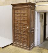 An early 20th century French oak notaries cabinet with twenty fall front compartments, width