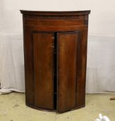 A 19th century George III bow-fronted hanging mahogany corner cupboard, width 84cm, depth 59cm,