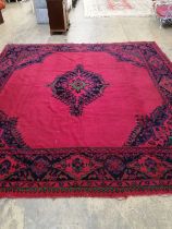 An Afghan red ground carpet, 330 x 314cm