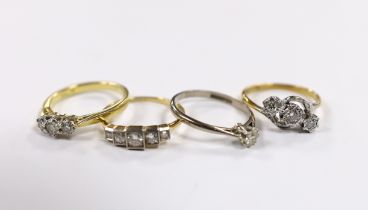 Four assorted 18ct and diamond set rings, including two three stone, a five stone and solitaire,