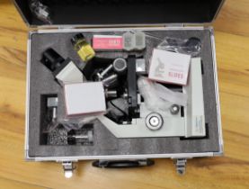 A cased binocular Apex Researcher Compound Microscope with a selection of accessories, slides,