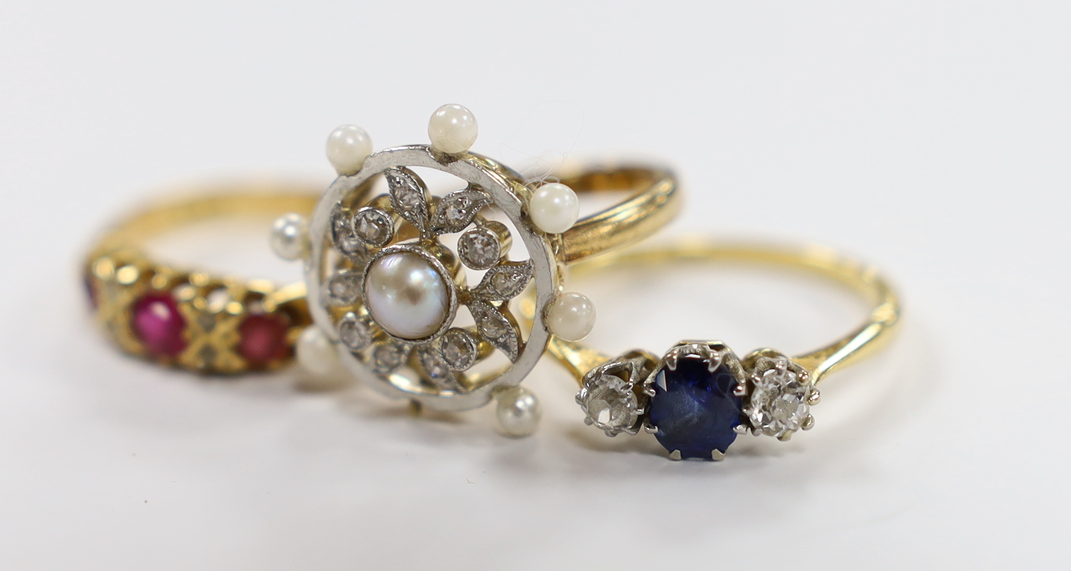 An 18ct, sapphire and diamond set three stone ring, a George V 18ct gold and three red stone set - Image 2 of 3