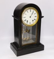 A slate cased domed mantle clock, with enamelled dial striking on a bell, with black Roman