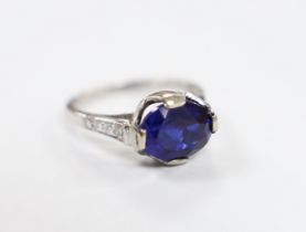 A plat. and iridium, single stone oval cut synthetic sapphire set ring, with graduated diamond