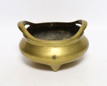 A Chinese bronze tripod censer with twin handles, mark to the base, 14cm wide