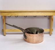 A graduated set of five French copper pans and a pine hanging rack
