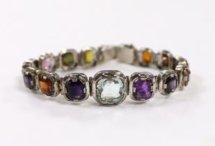 A white metal (tests as silver) and graduated multi gem set bracelet, 17.5cm, the stones including