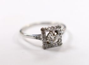 A 1940's 18ct white metal and single stone diamond ring, with diamond set square border and
